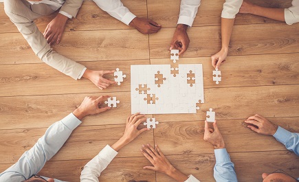 Mani di persone che compongono puzzle